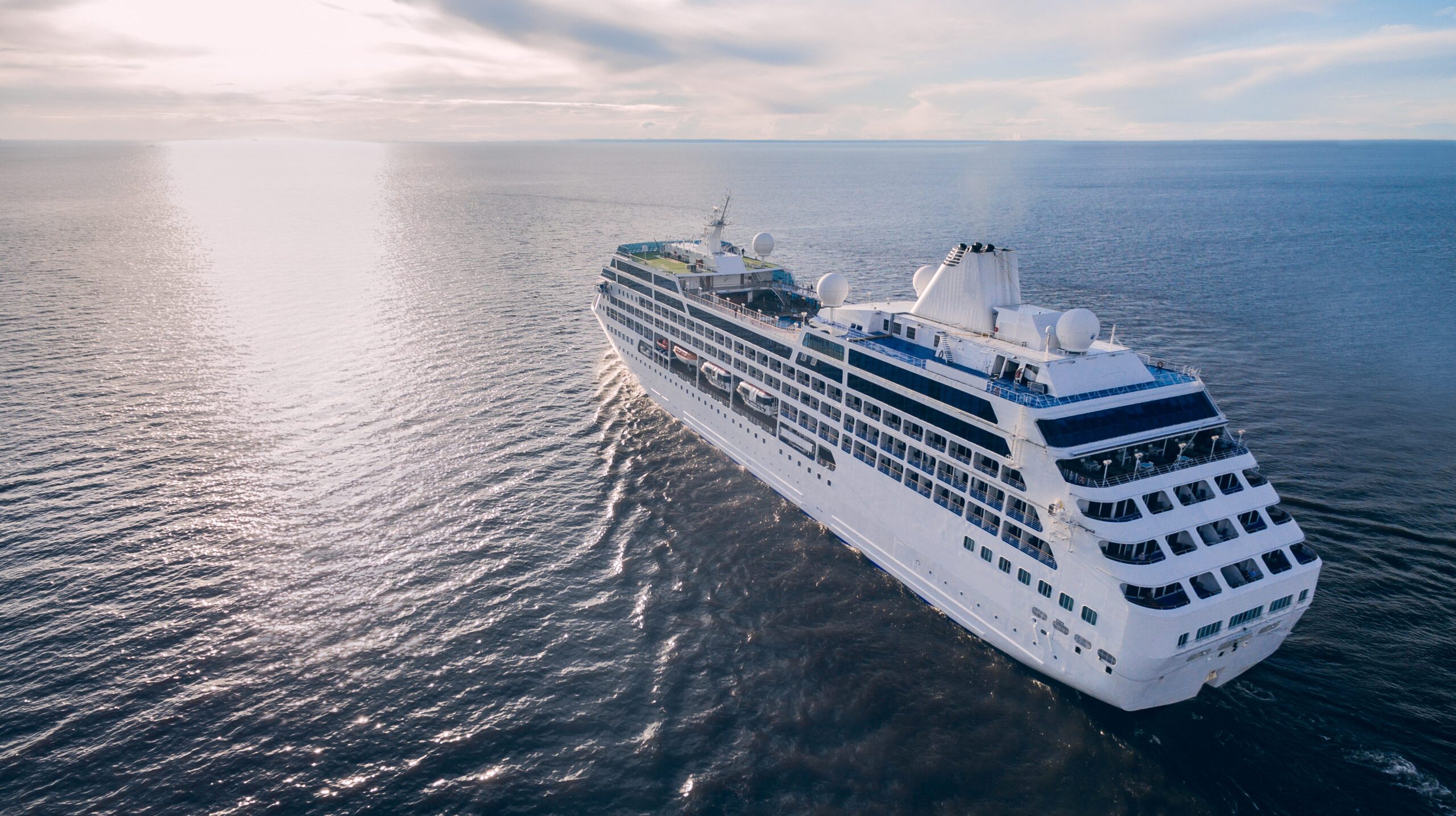 Aerial view of cruise liner sailing in the open sea at sunset