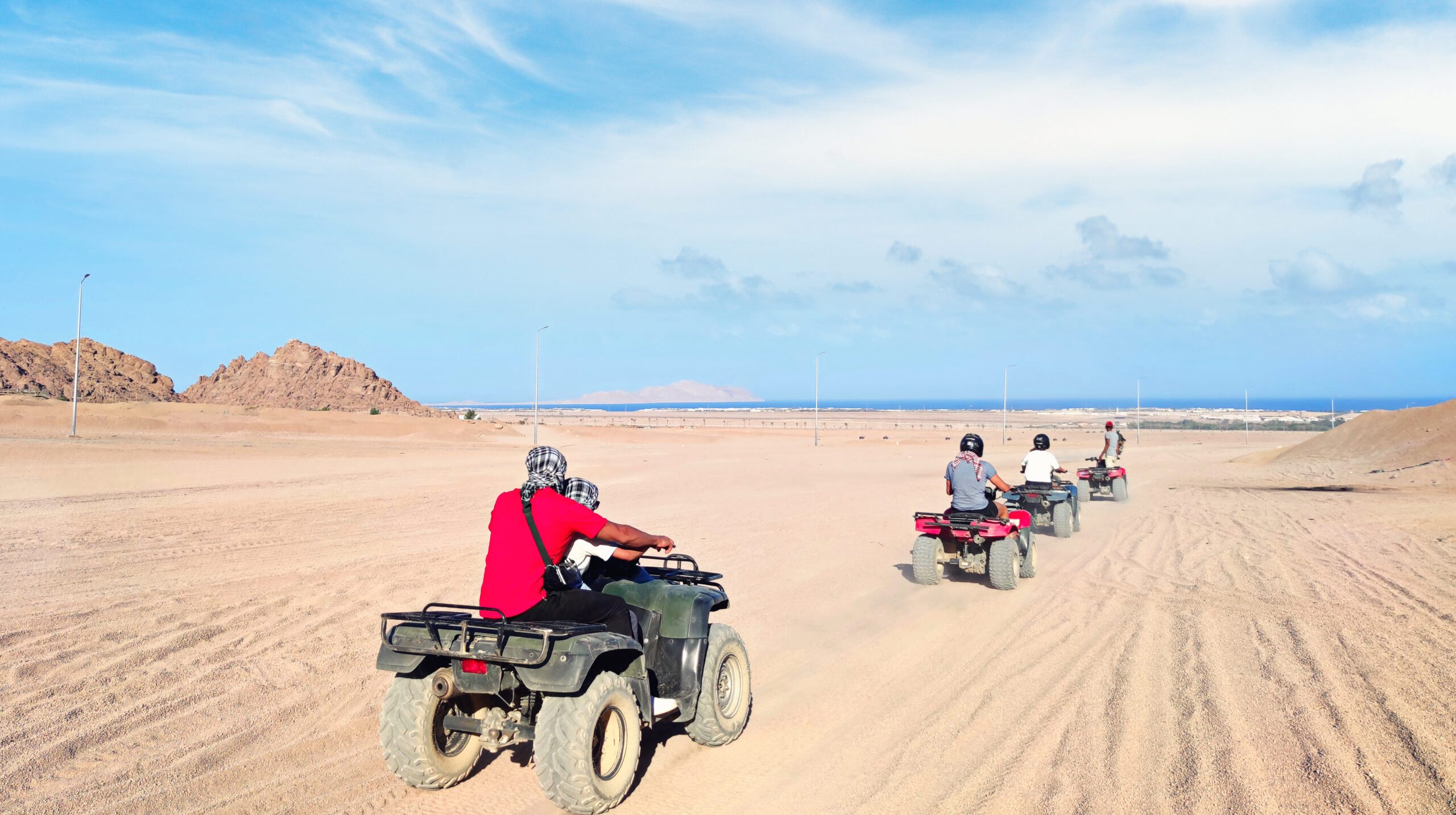 man driving quad bike in Sinai desert. Happy tourist having fun during summer vacation. ATV rally.