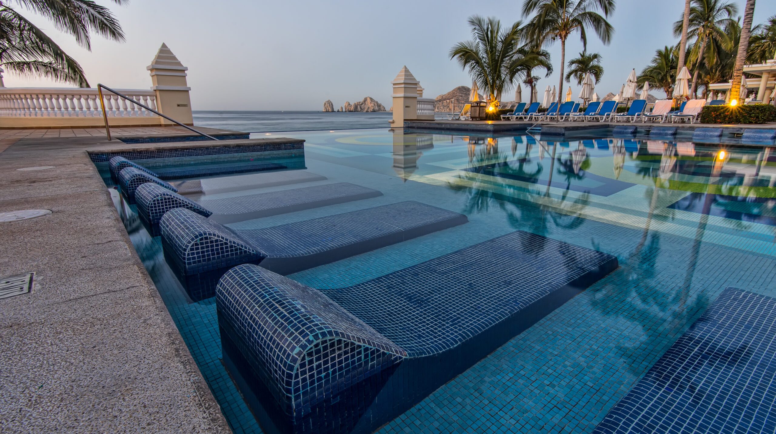 Blue Sun Loungers On Swimming Pool