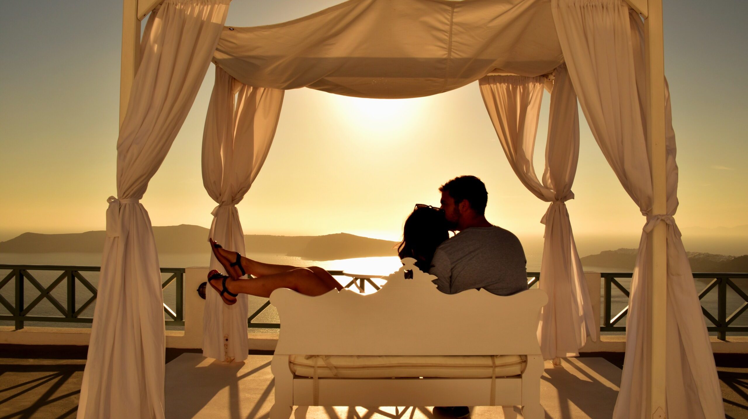 couple-sitting-bench-terrace-sunset