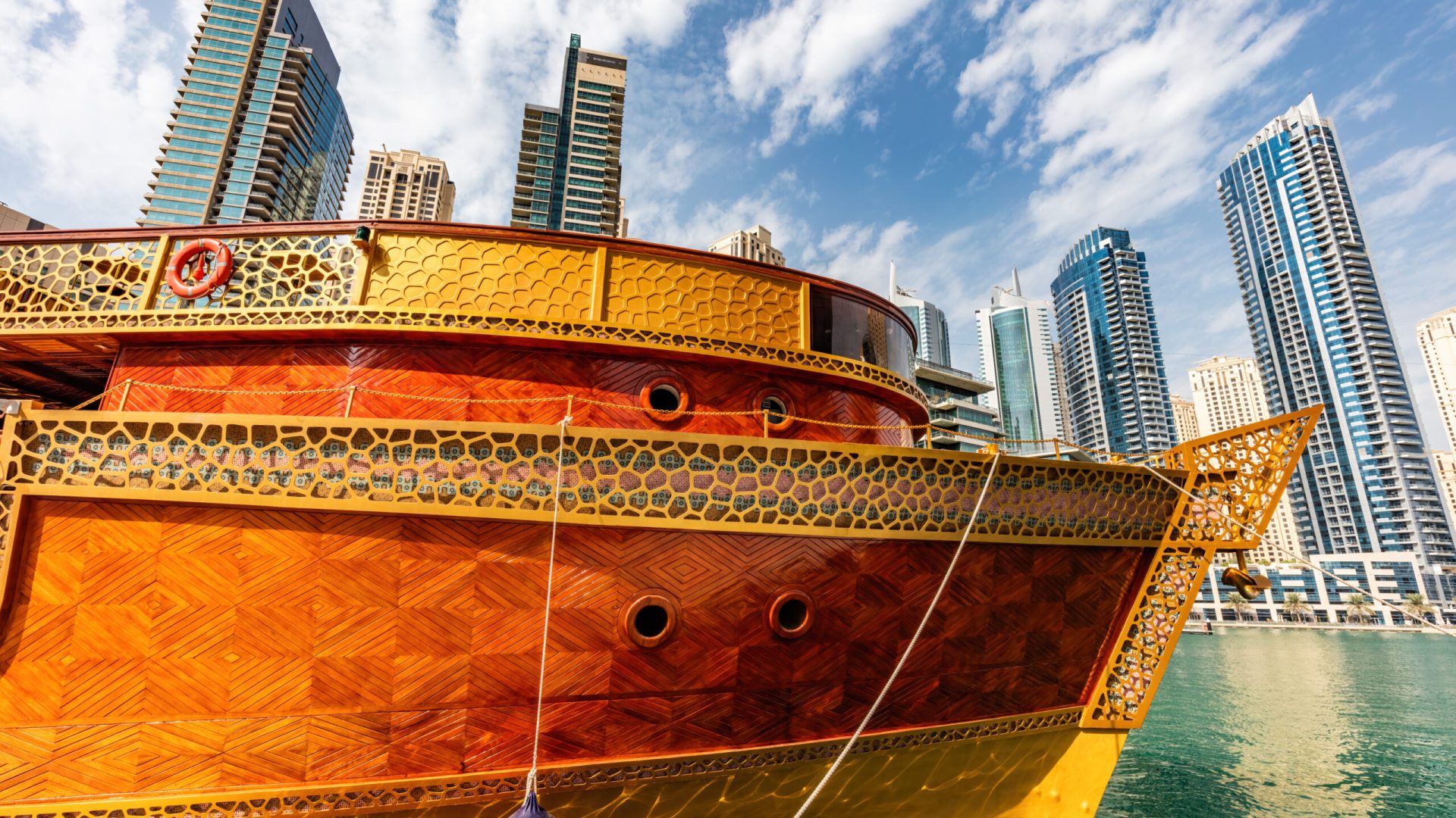 Dubai marina and tourist ship in UAE. High-rise residential buildings, business skyscrapers