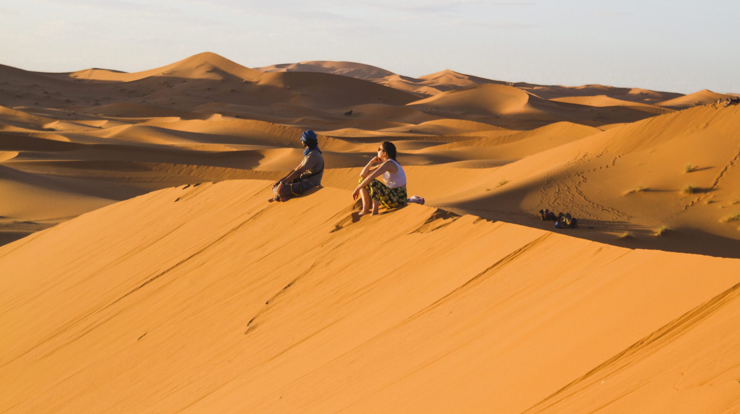 extreme-long-shot-two-people-sitting-top-dune