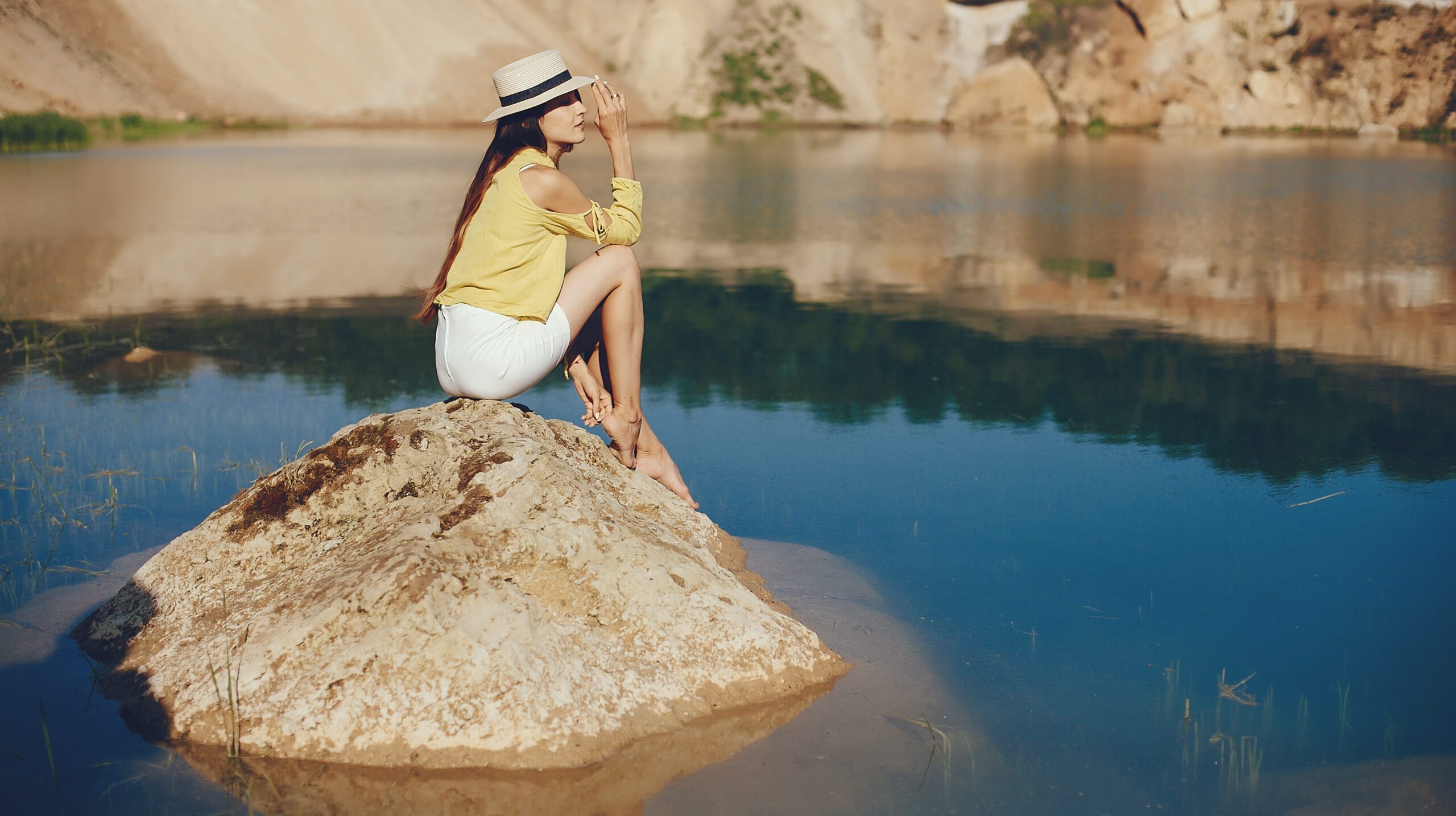 Pretty girl in a brown hat. Woman near blue water.