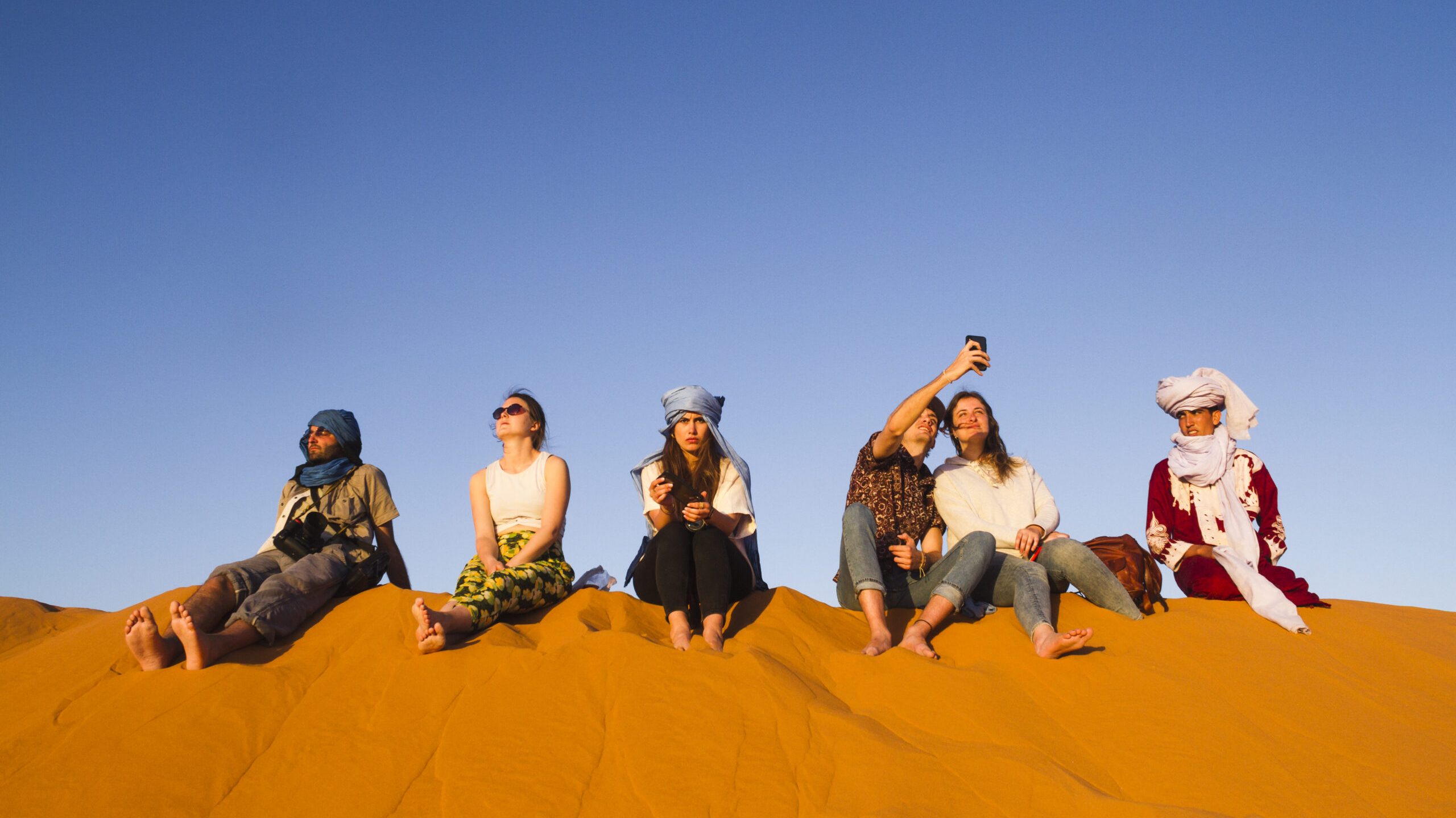 group-people-sitting-top-dune