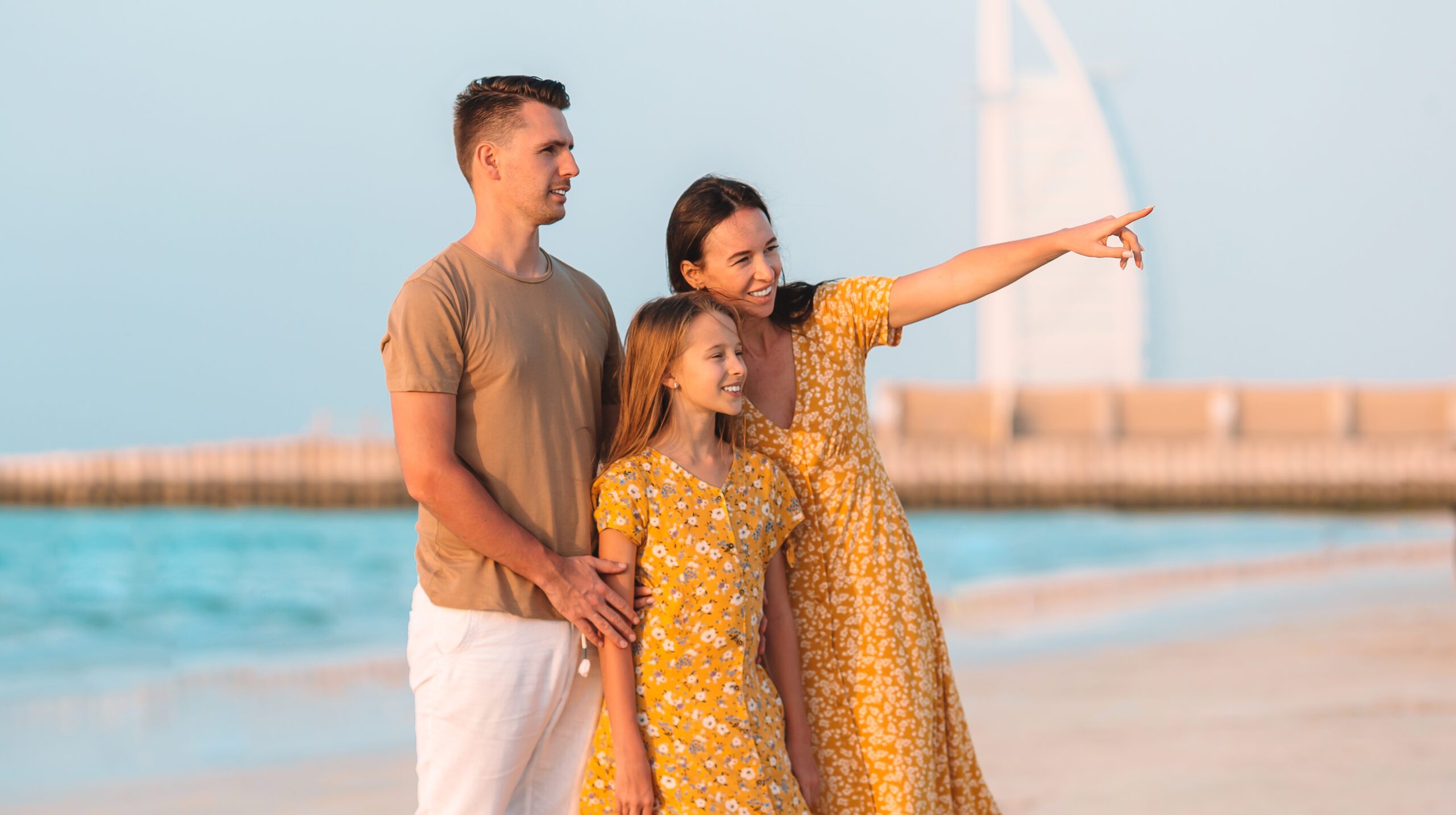Happy family on the beach at summer vacation in Dubai, UAE. United Arab Emirates famous tourist destination.