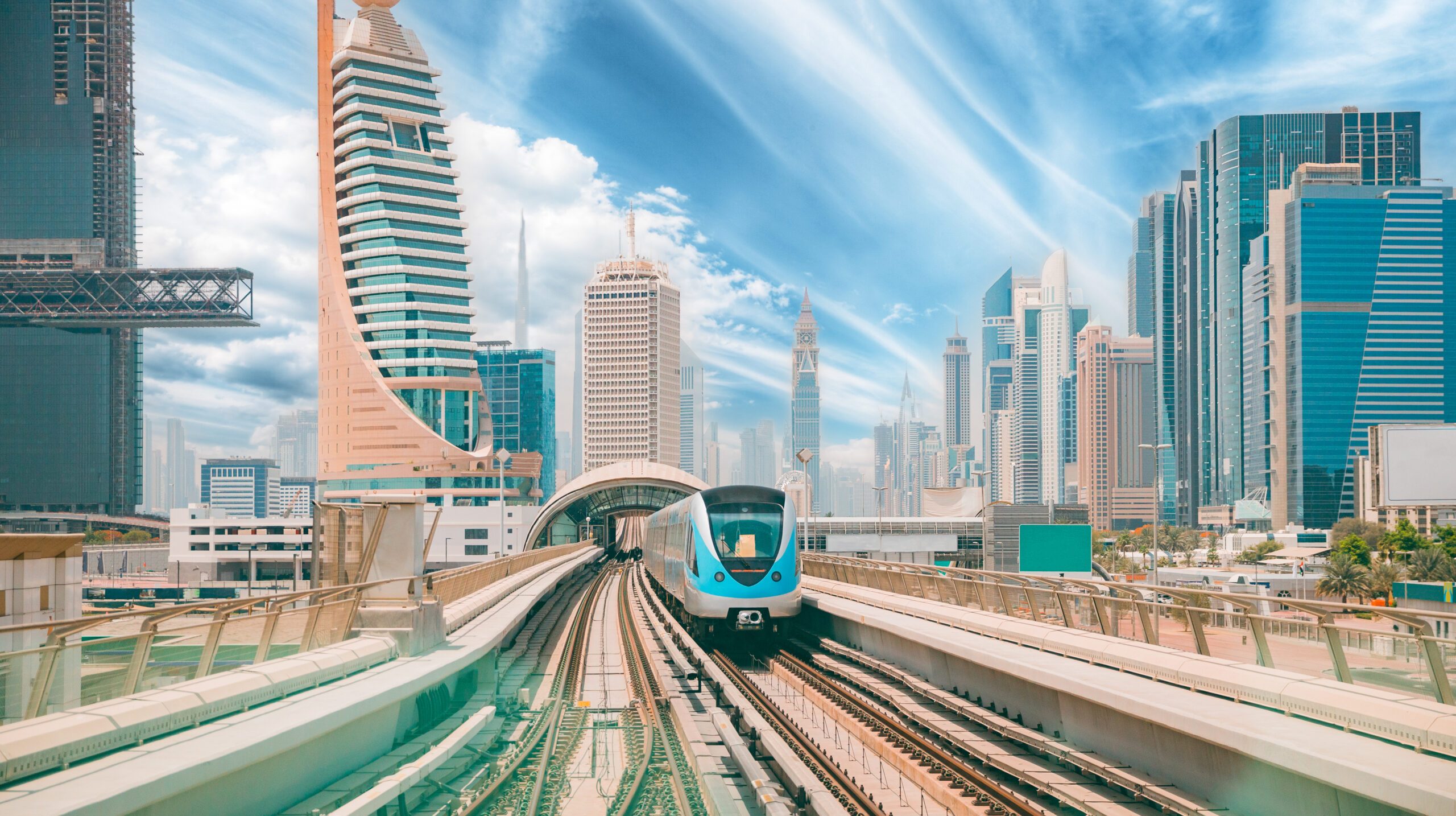 Monorail Subway train rides among glass skyscrapers in Dubai. Traffic on street in Dubai. Cityscape skyline. Urban background. Altered sky.