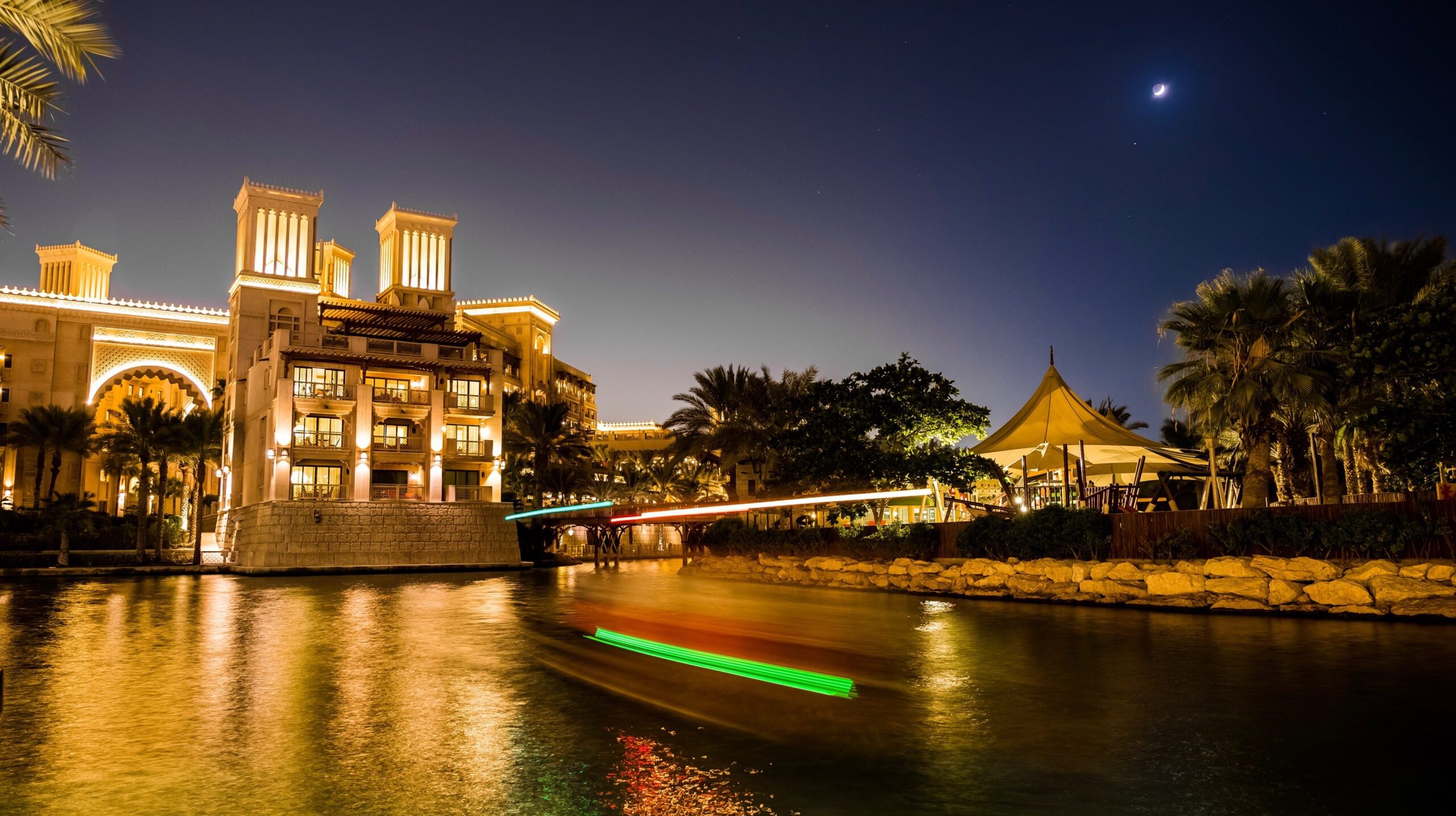 illuminated-building-by-river-against-sky-night