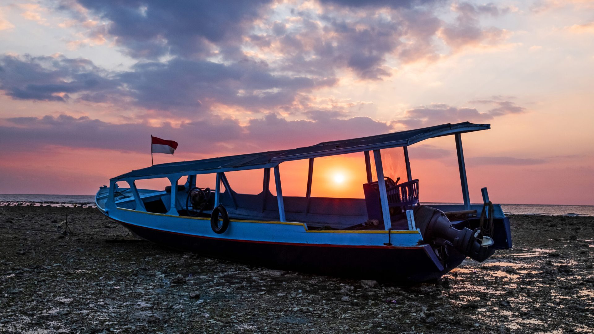 Indonesian sunset... Traditional boat in gili trawangan beach.
