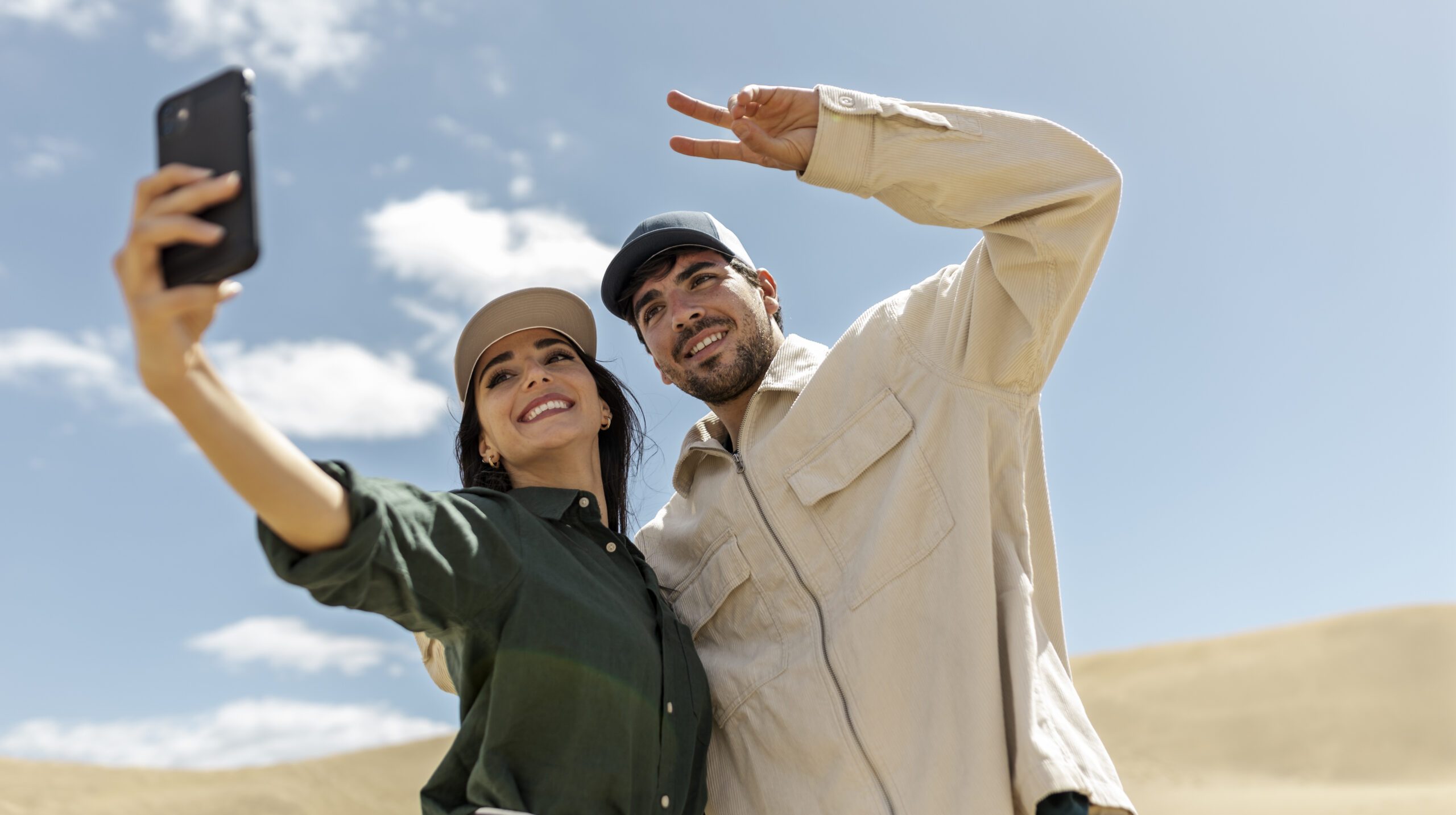 low-angle-couple-taking-selfie-desert