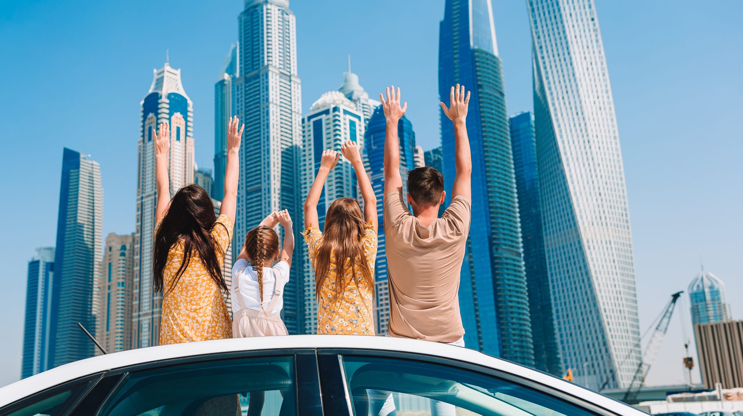Family on vacation in Emirates. Family of four on car vacation on background of skyscrapers in Dubai
