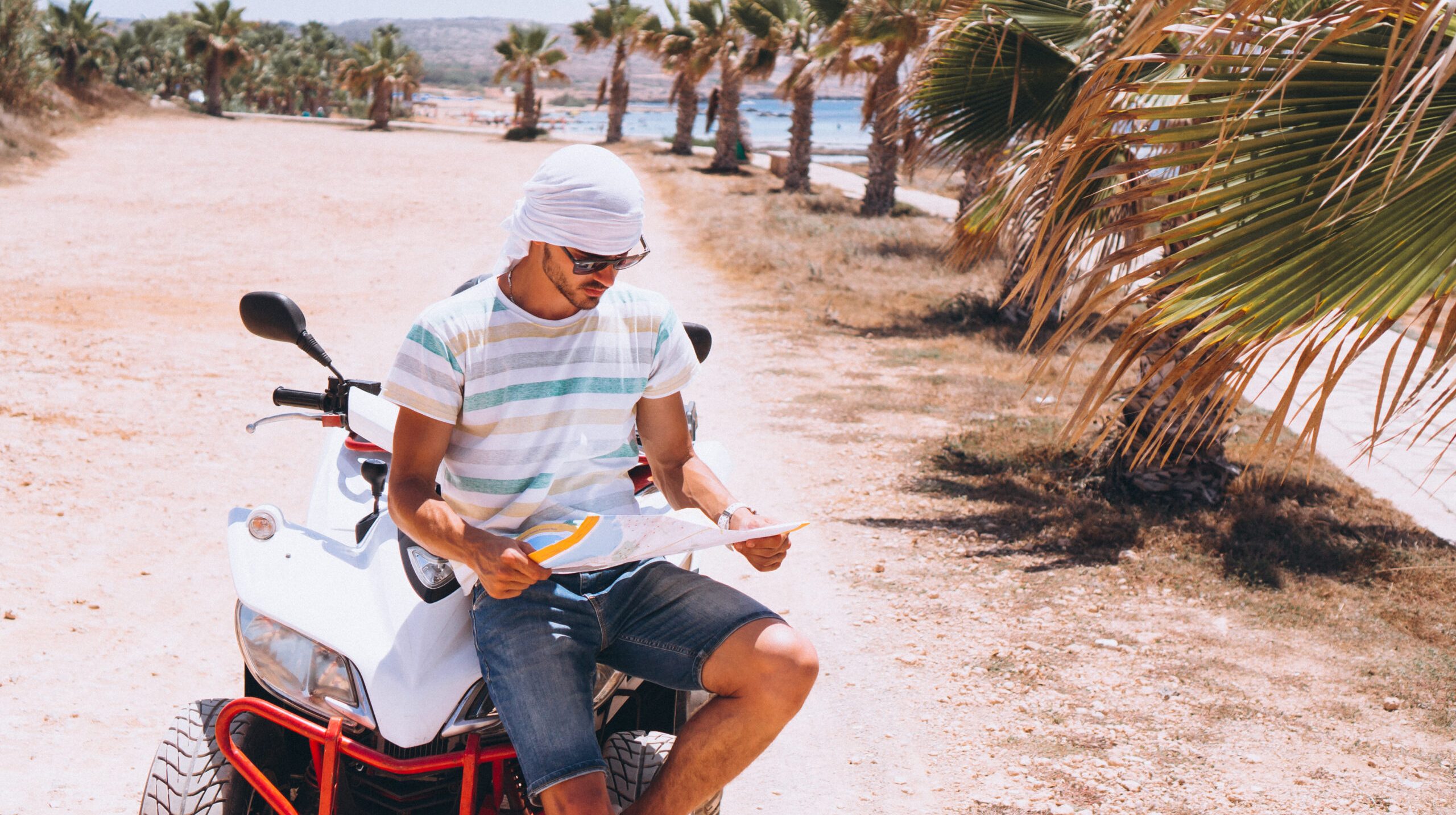 Man with map travalling on atv by the sea