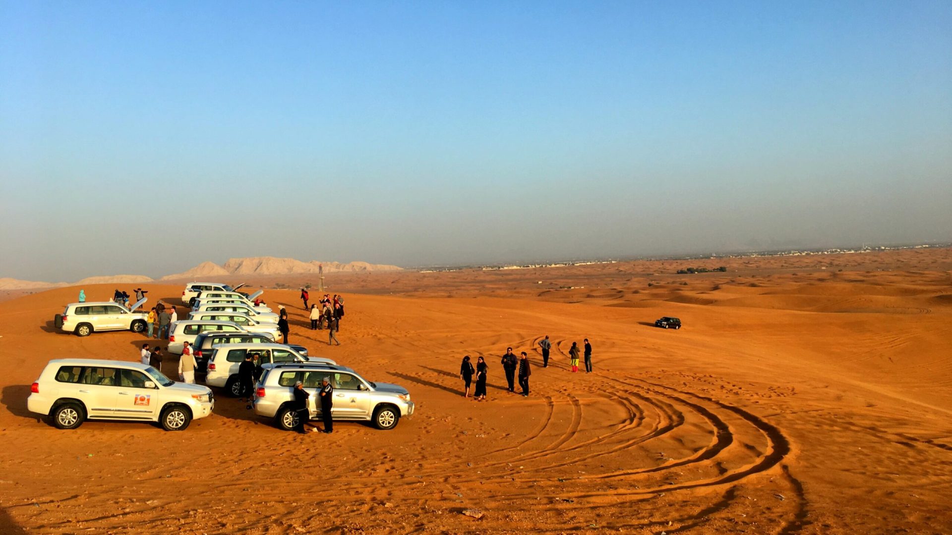 people-with-cars-desert-against-blue-sky