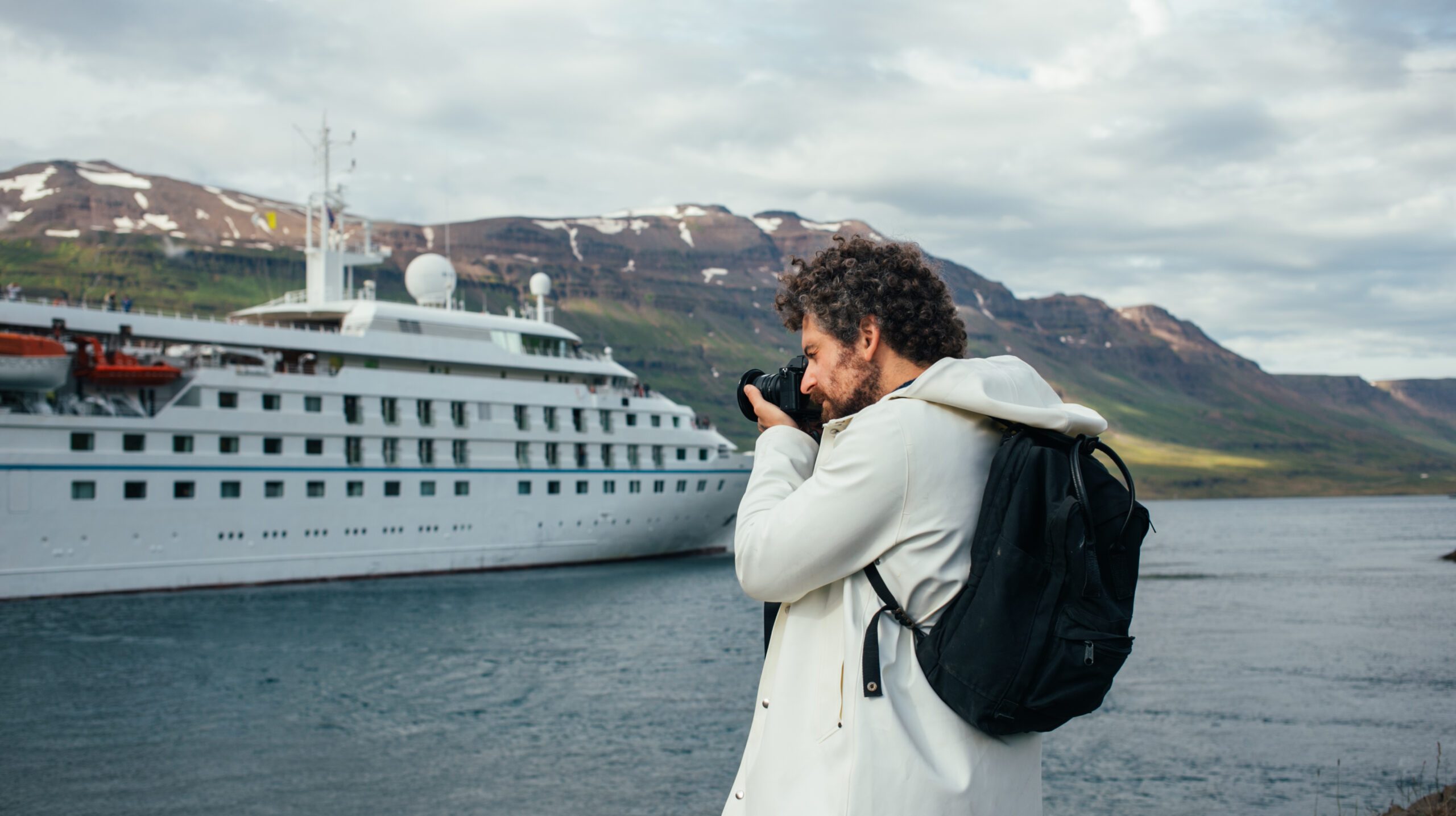 Photographer make photos of cruise ship in fjord