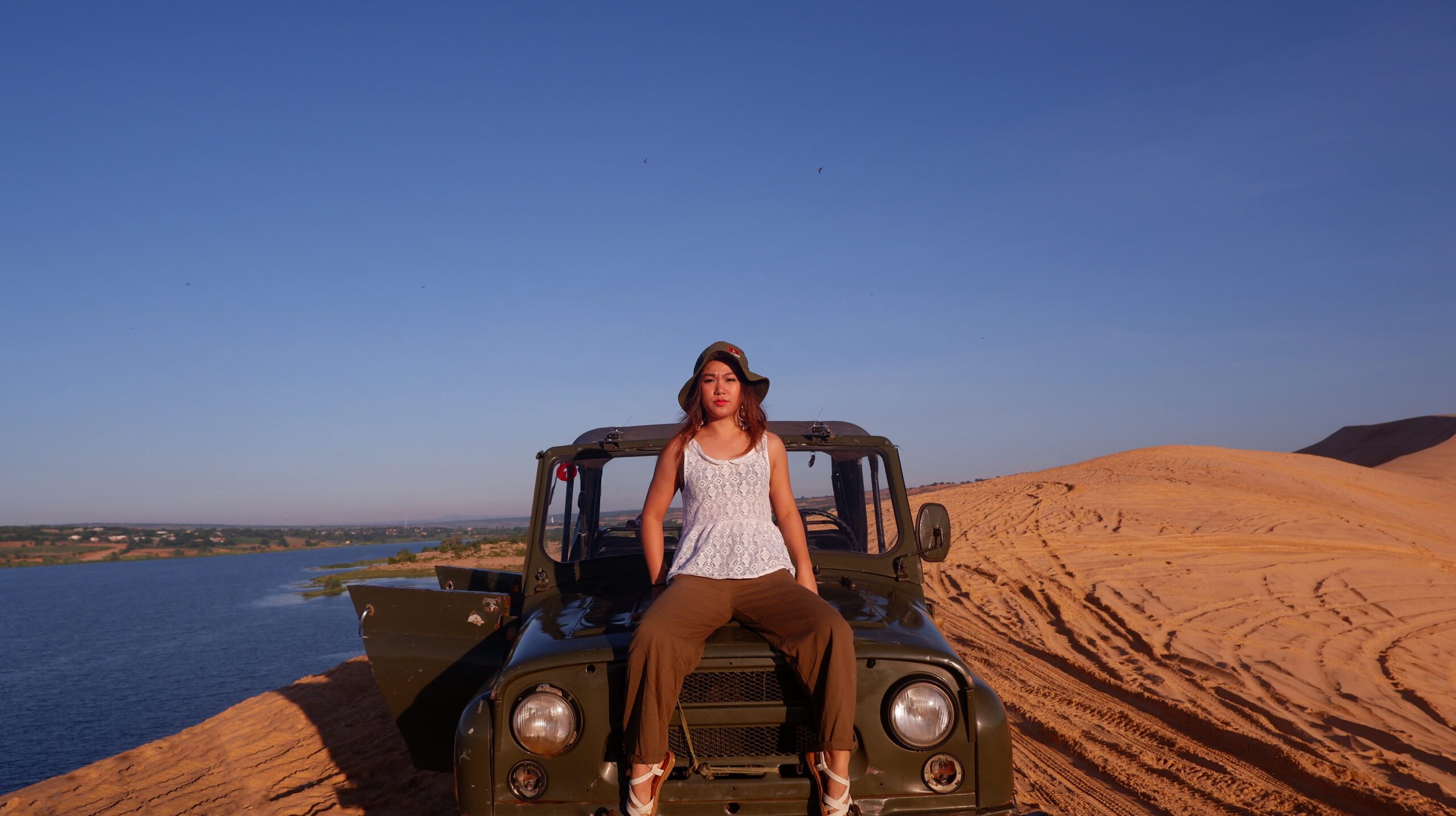 portrait-woman-sitting-off-road-vehicle-against-clear-blue-sky
