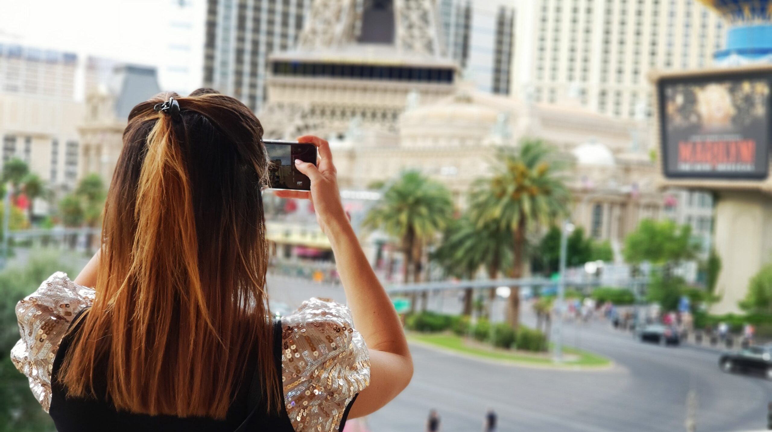 rear-view-woman-photographing-with-mobile-phone-city
