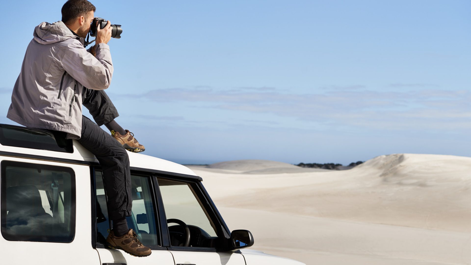 Road Trip, dunes and man in nature for photography, desert landscape and travel for holiday. Pictures, 4x4 and nomad male person in Sahara terrain, outdoor and transport in dry climate and scenery.