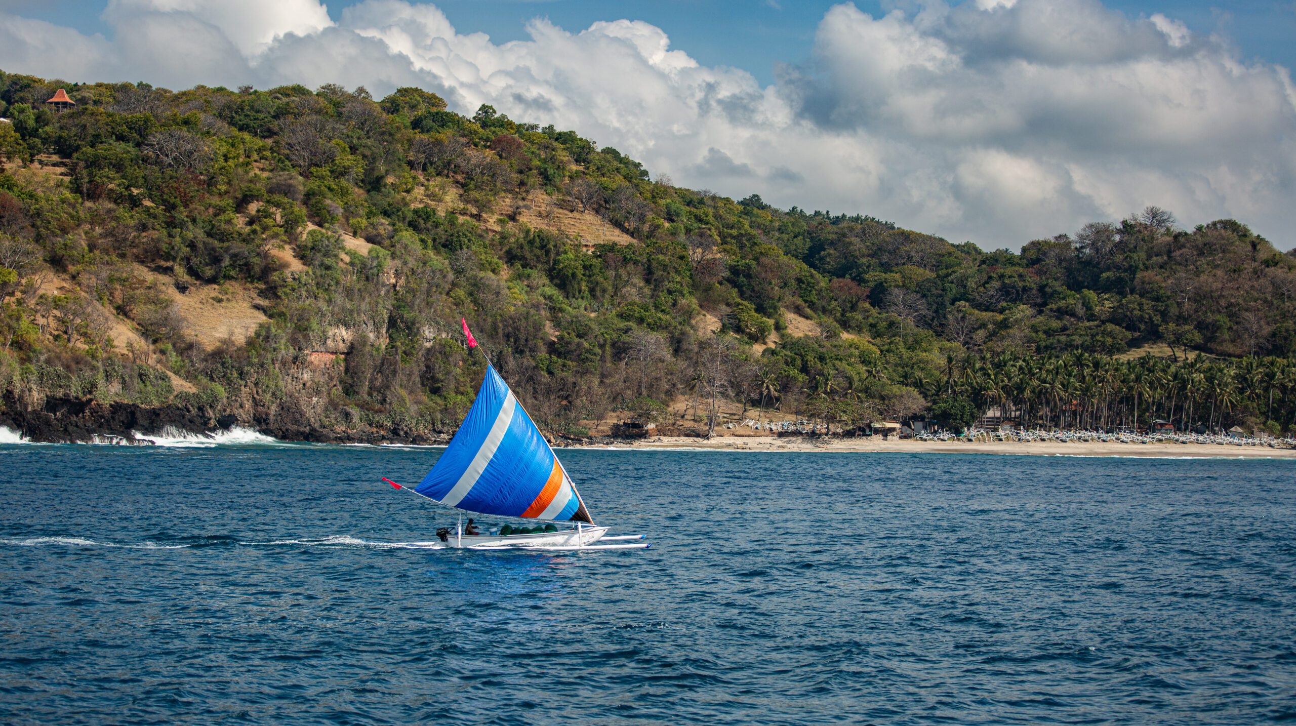 small sailboat floats on water with amazing mountain views. High quality photo