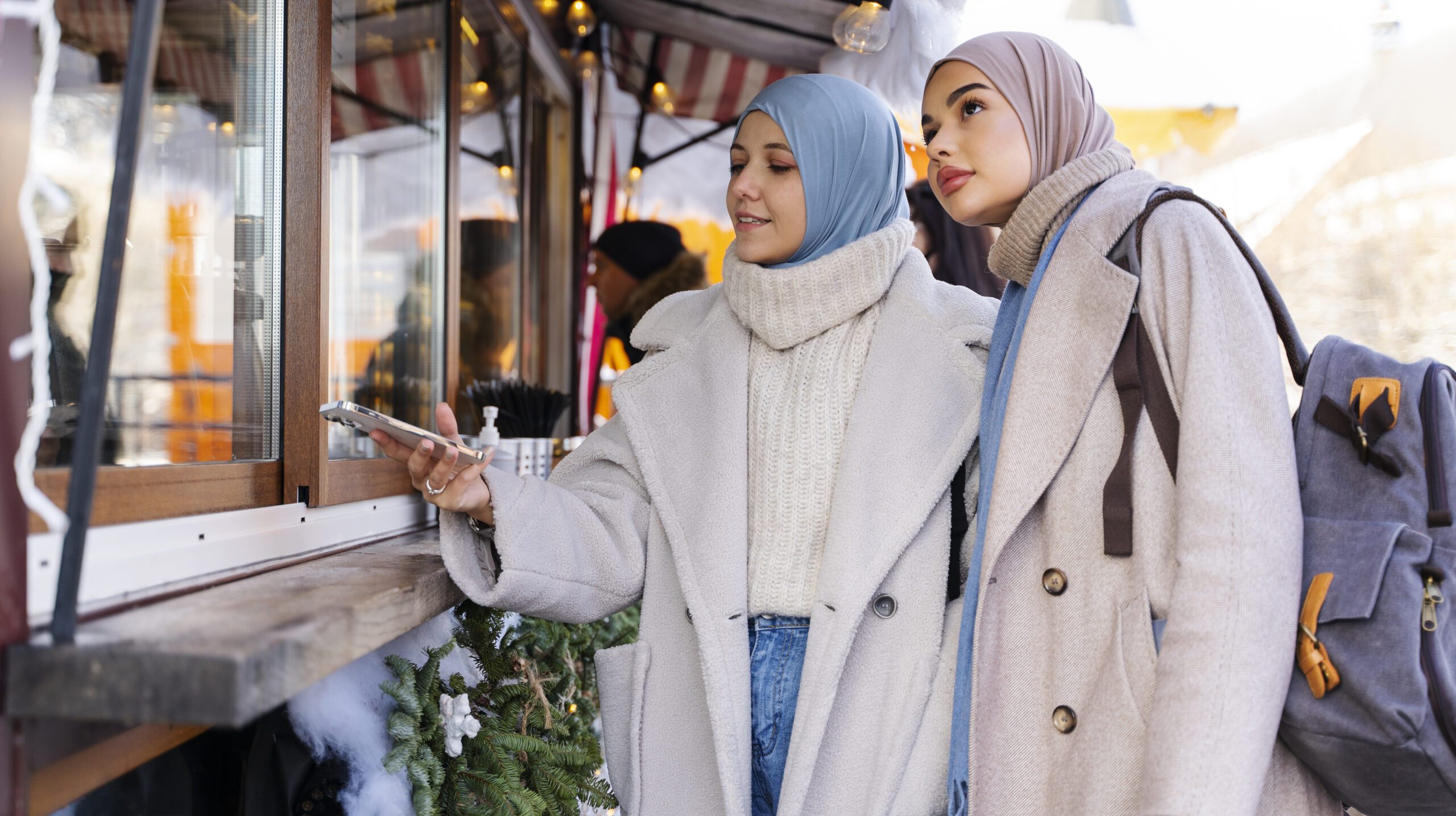 two-muslim-women-checking-out-pastry-shop-while-traveling
