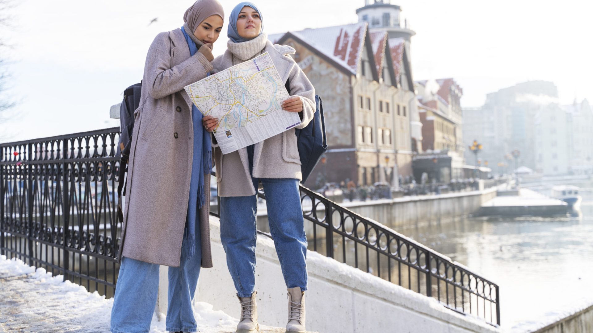 two-muslim-women-with-hijabs-consulting-map-while-traveling-city