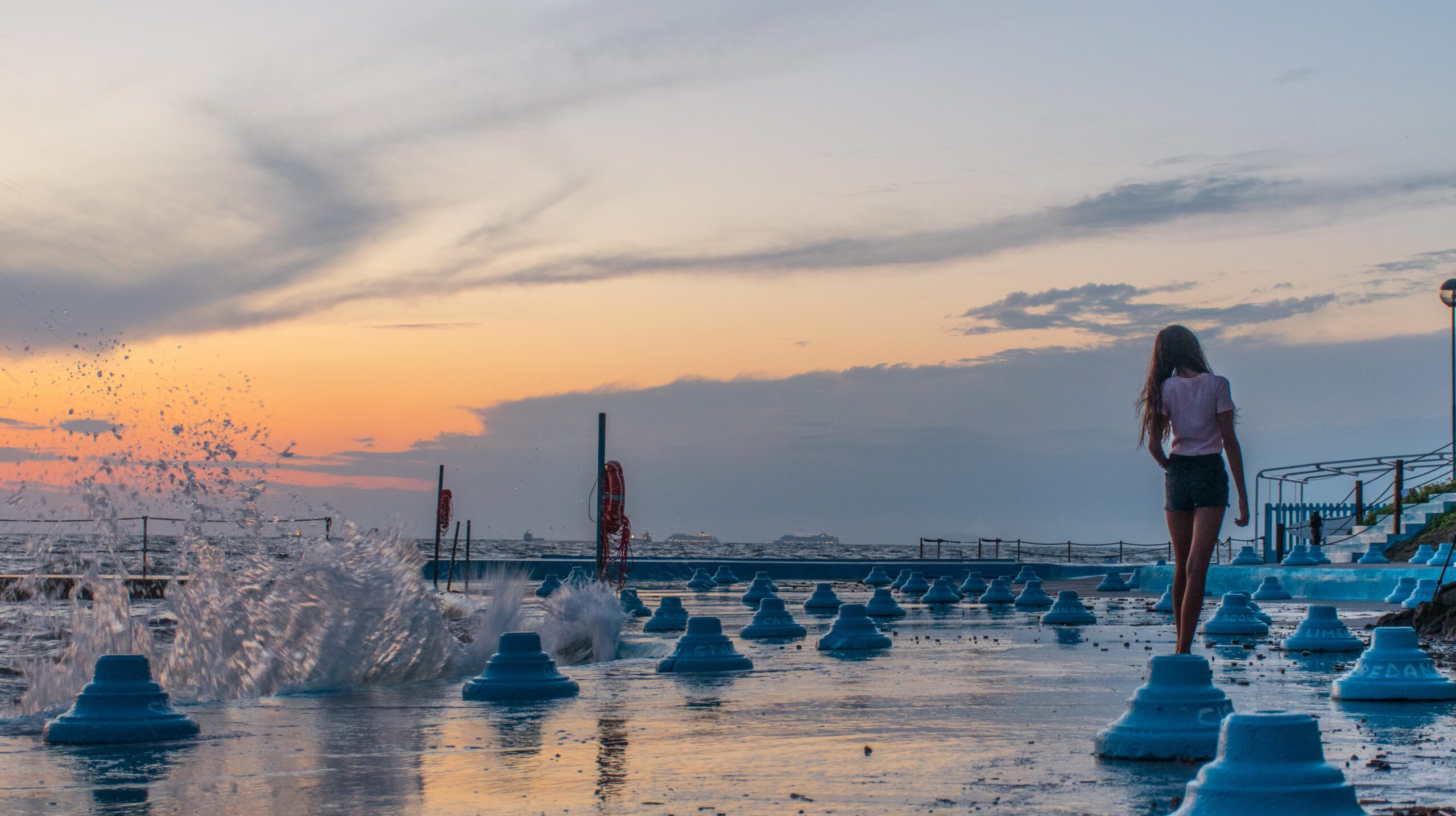 woman-walking-built-structure-fountain-against-sky-sunset