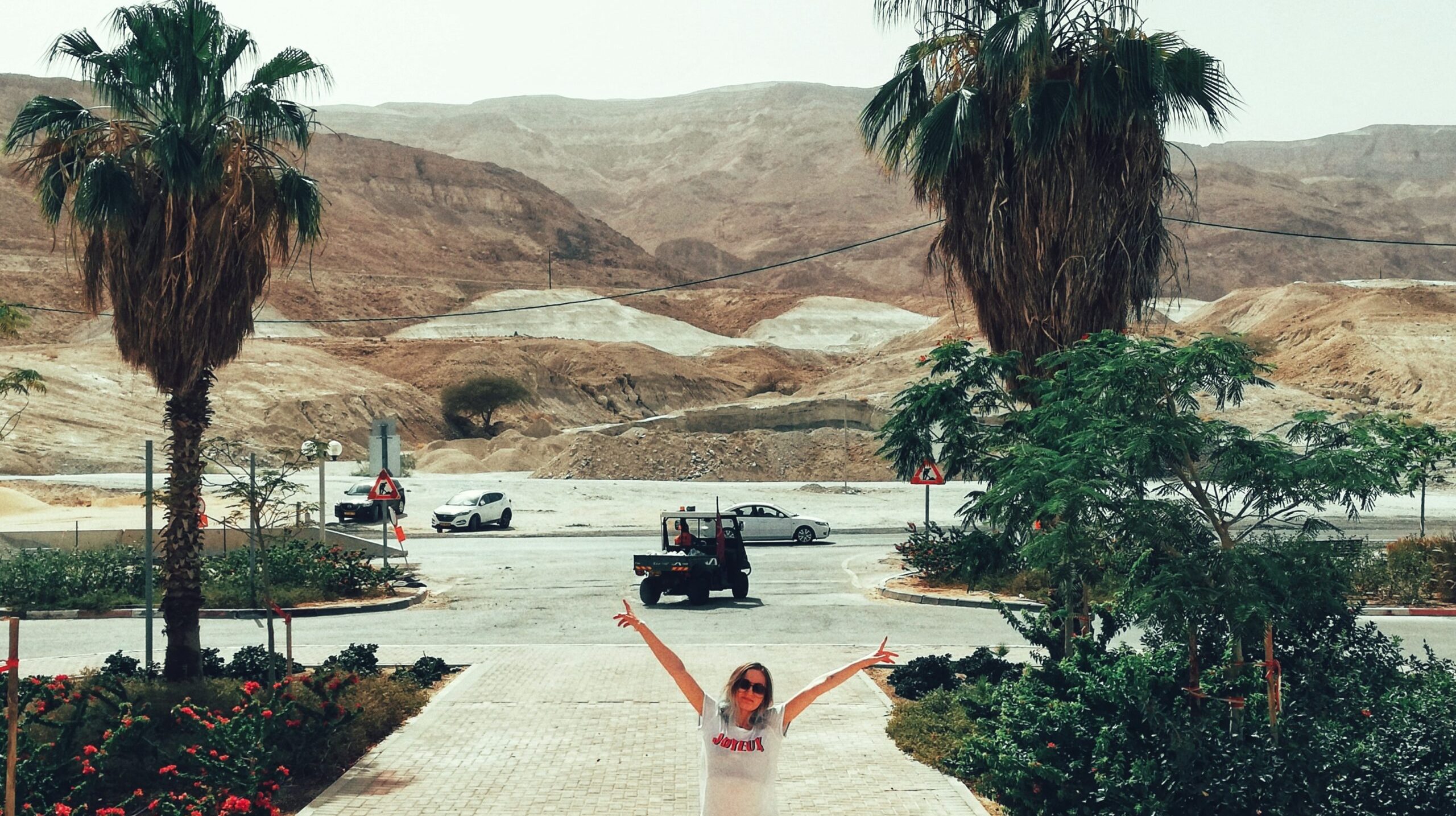 woman-with-arms-raised-standing-footpath-against-mountain