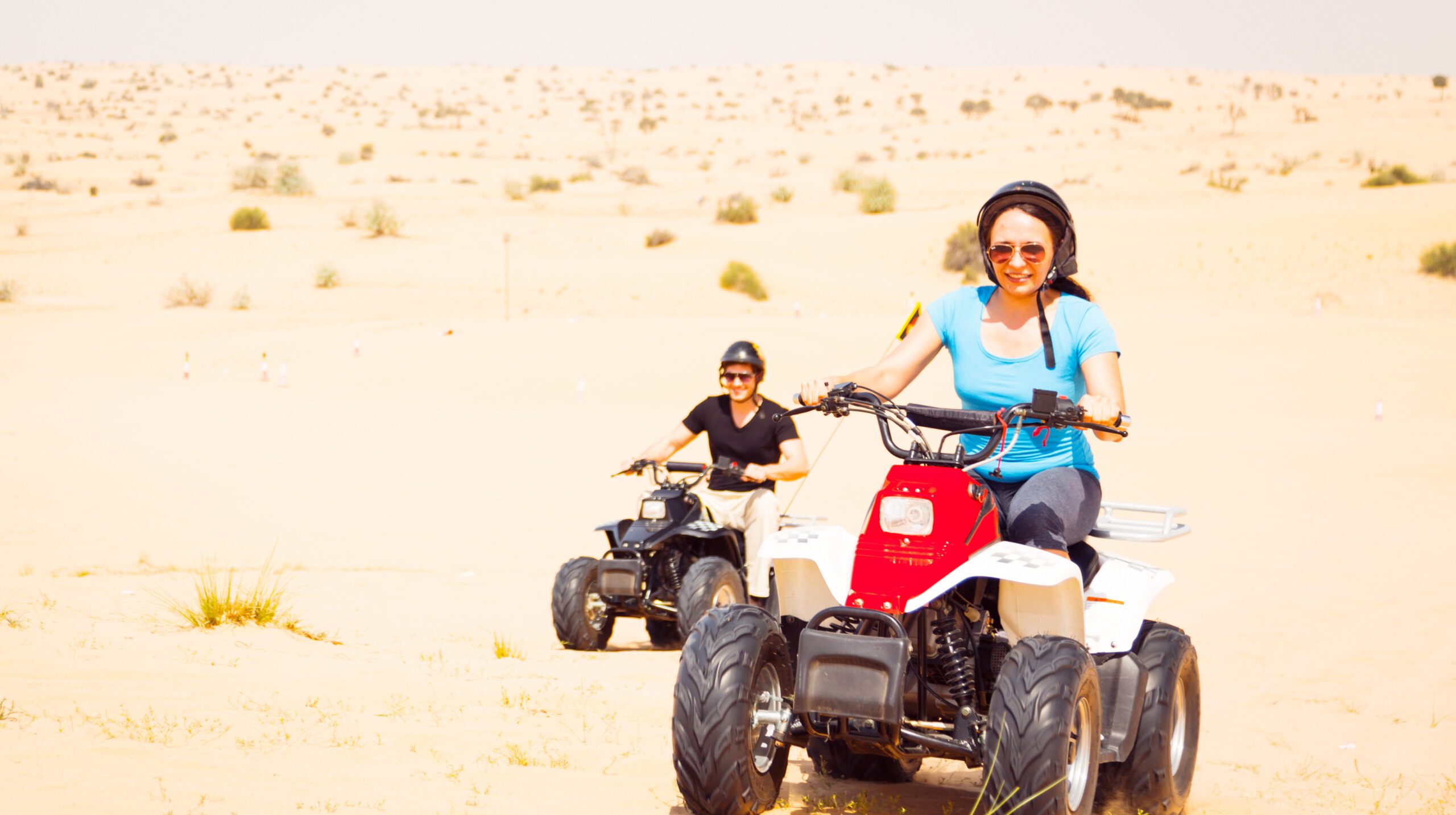 young-man-woman-riding-quadbike-desert-sunny-day