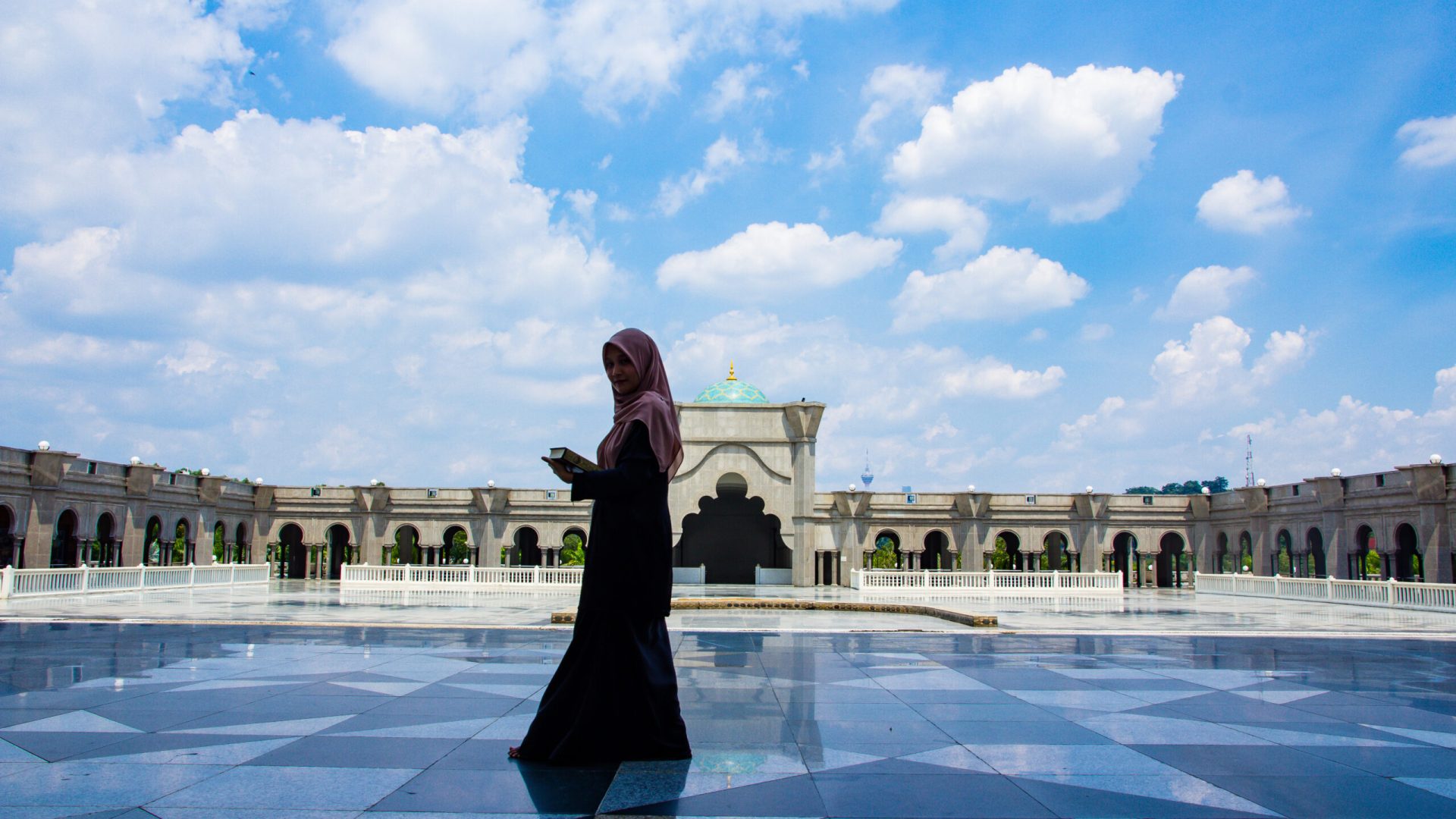 young-woman-holding-holy-book-while-walking-outdoors