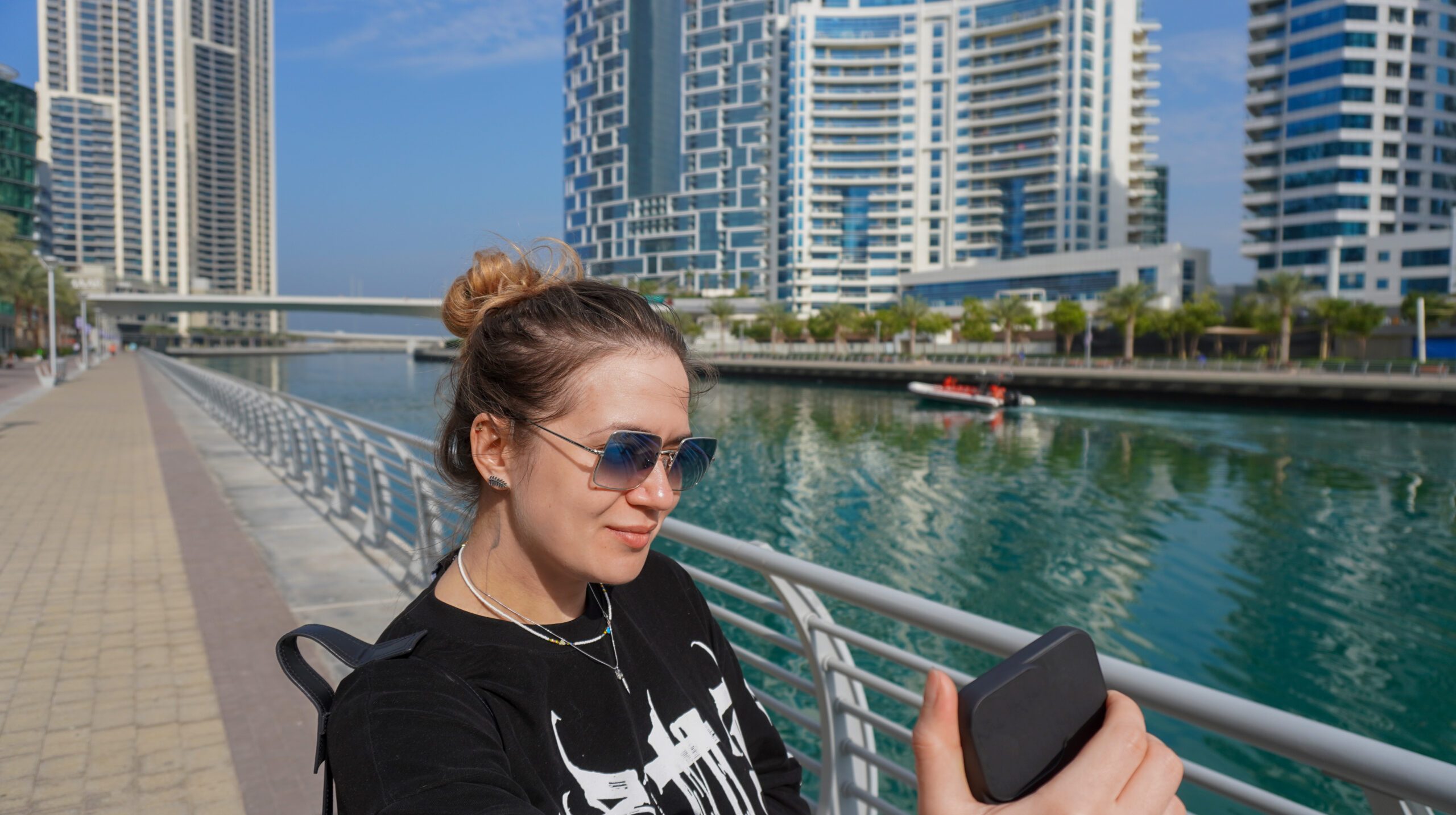 young beautiful woman walking along Dubai Marina in Dubai, UAE,