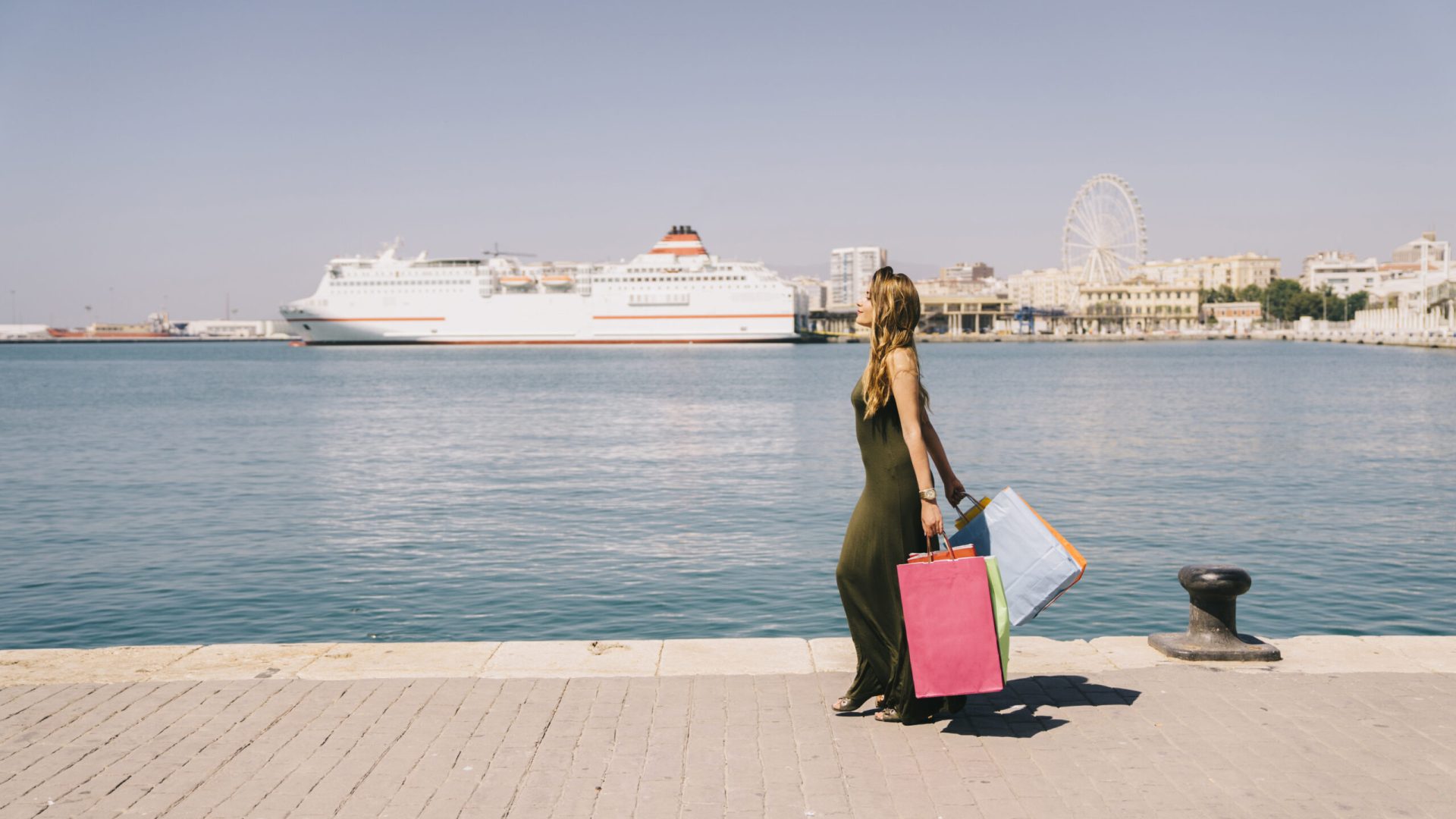 young-woman-walking-seaside-after-shopping