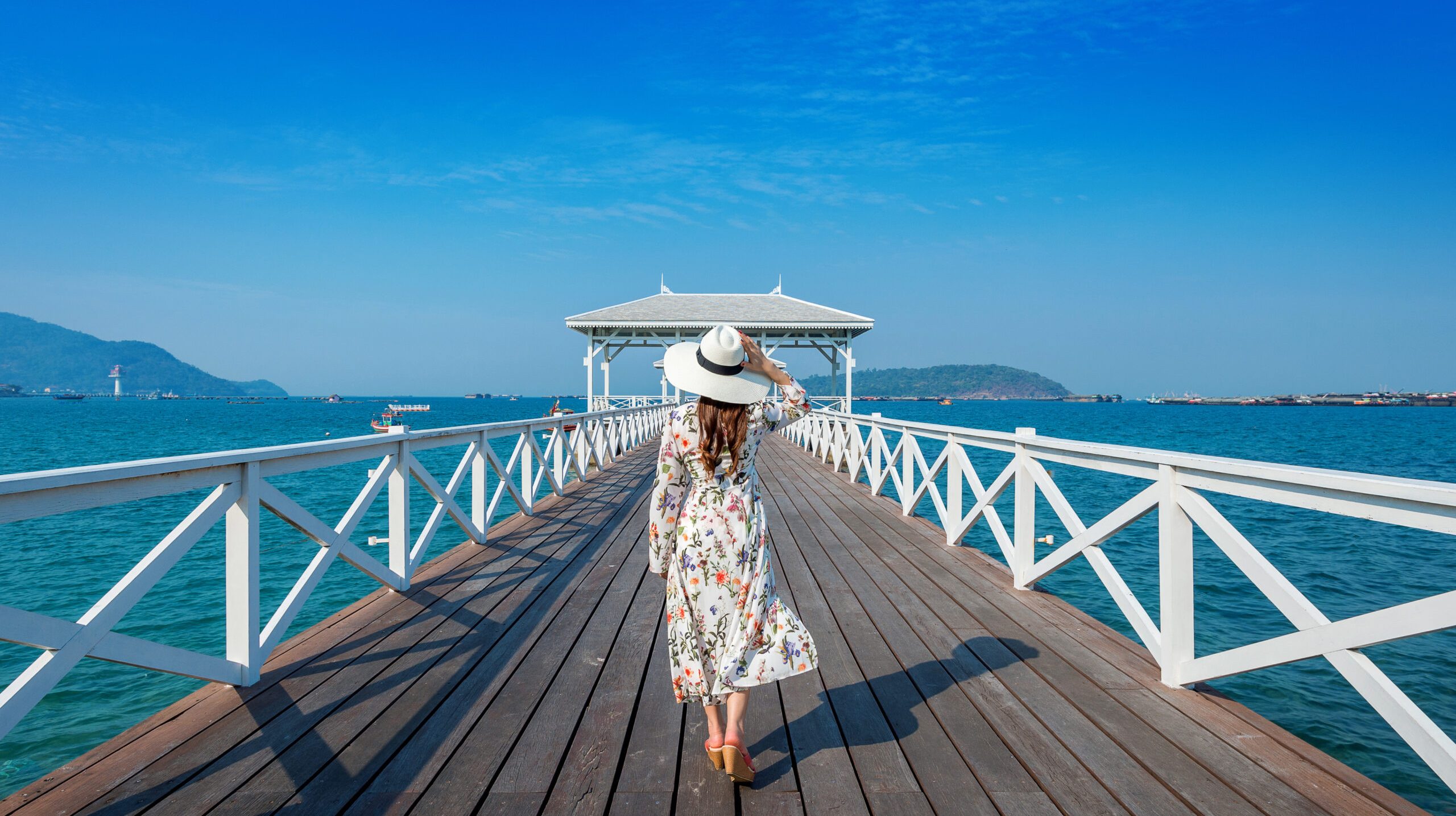 Young woman walking on wooden bridge in Si chang island, Thailand.